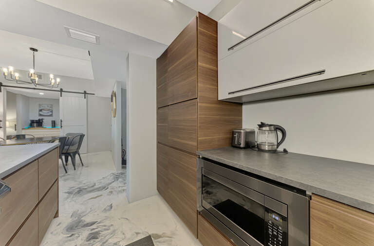 You'll love preparing meals in this sleek modern kitchen with stunning wood cabinets, granite counters, and premium appliances for your perfect getaway.