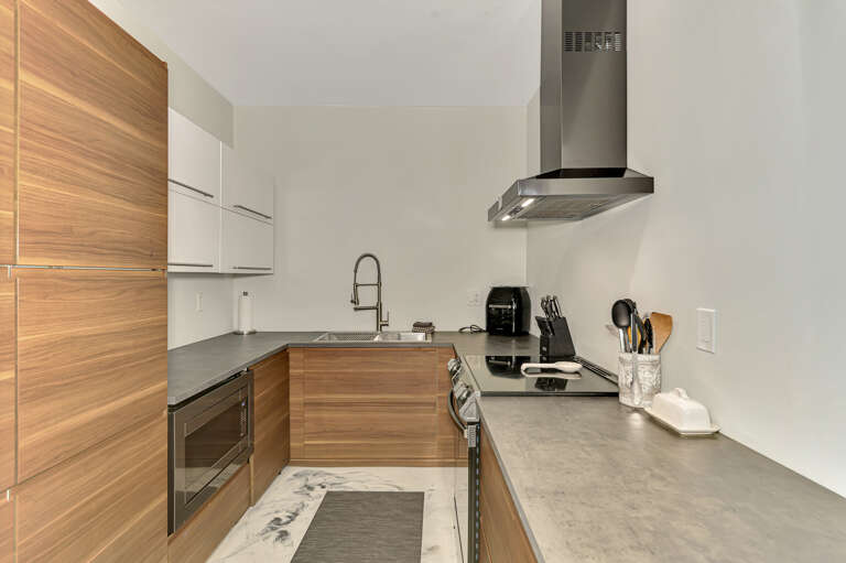 Step into your sleek modern kitchen with warm wood finishes, stainless steel appliances, and everything you need to create memorable meals.