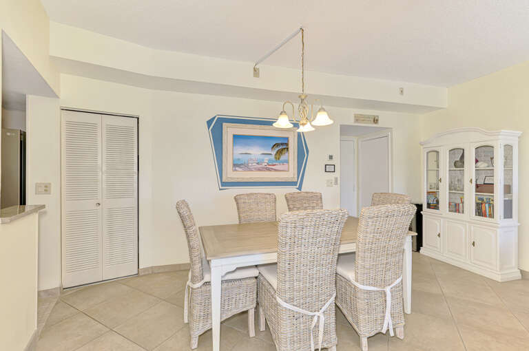 Your bright dining space features coastal charm with wicker chairs and tropical artwork, perfect for memorable meals together.