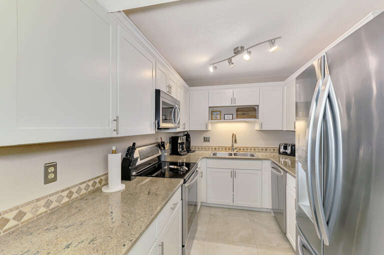 Your fully equipped kitchen features granite countertops, stainless steel appliances, and crisp white cabinetry for all your culinary adventures.