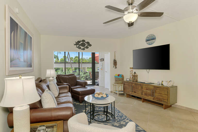 Unwind in your bright, airy living room with plush leather seating and tropical garden views through your sliding glass doors.