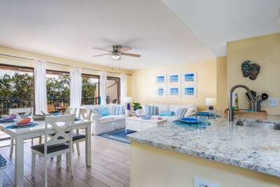 Your bright, open living space flows seamlessly from granite kitchen to comfortable seating area with balcony access.