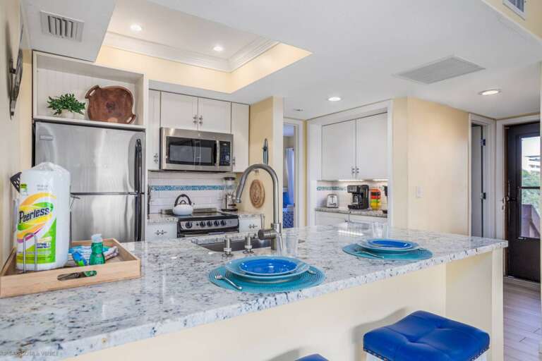 Step into your fully equipped kitchen with granite counters, stainless appliances, and thoughtful coastal touches that make cooking a joy.