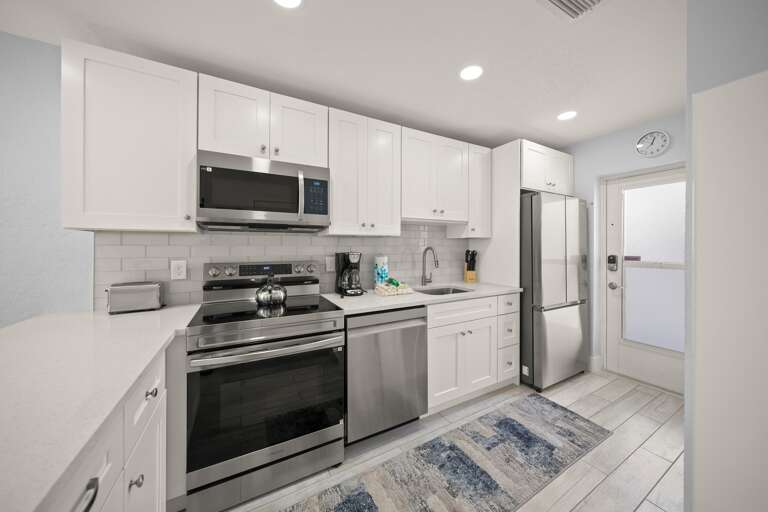 Your fully equipped kitchen features crisp white cabinets, stainless steel appliances, and clean countertopsâperfect for preparing home-cooked meals during your stay.