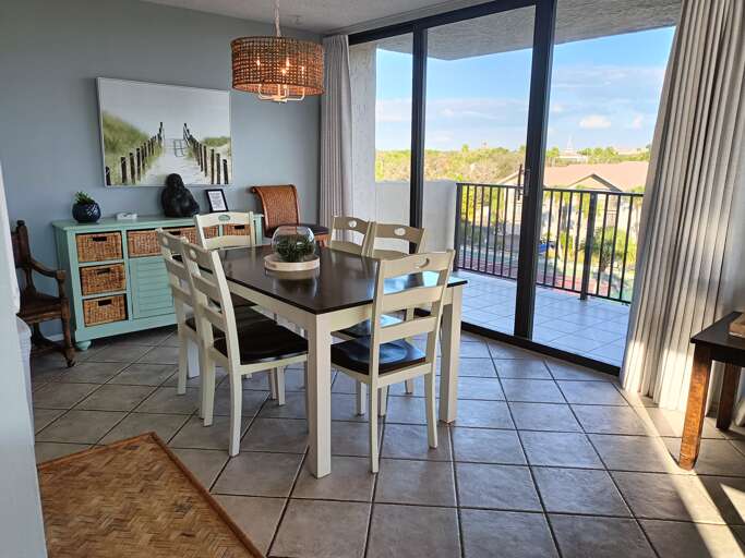 Your coastal dining space features gorgeous natural light and direct balcony access for memorable meals with views.