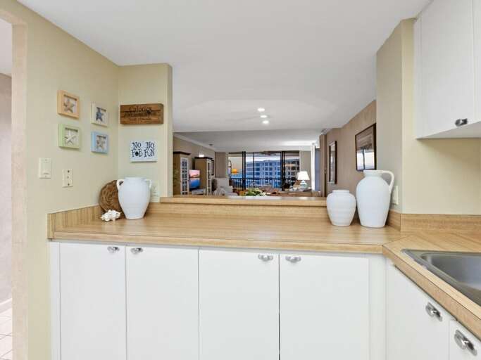 Cook with ease in your bright kitchen featuring warm wood countertops and thoughtful coastal touches that make meal prep a joy.