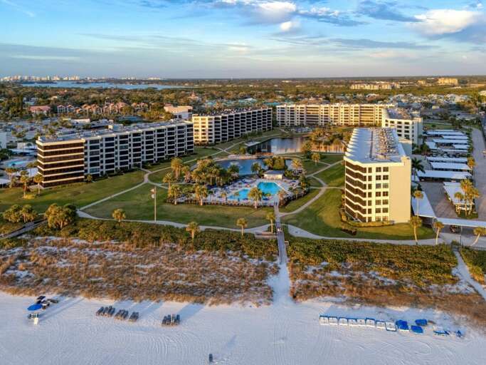Beachfront resort complex with multiple buildings, pool facilities, and direct beach access on pristine white sand coastline.