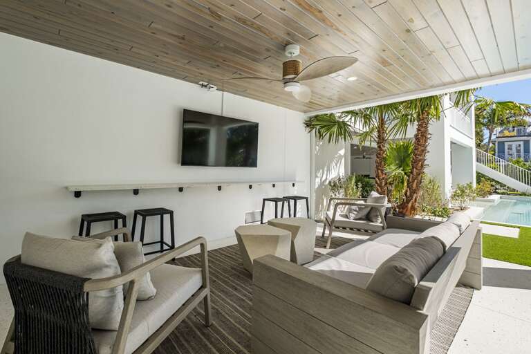 Private covered patio with furniture and TV