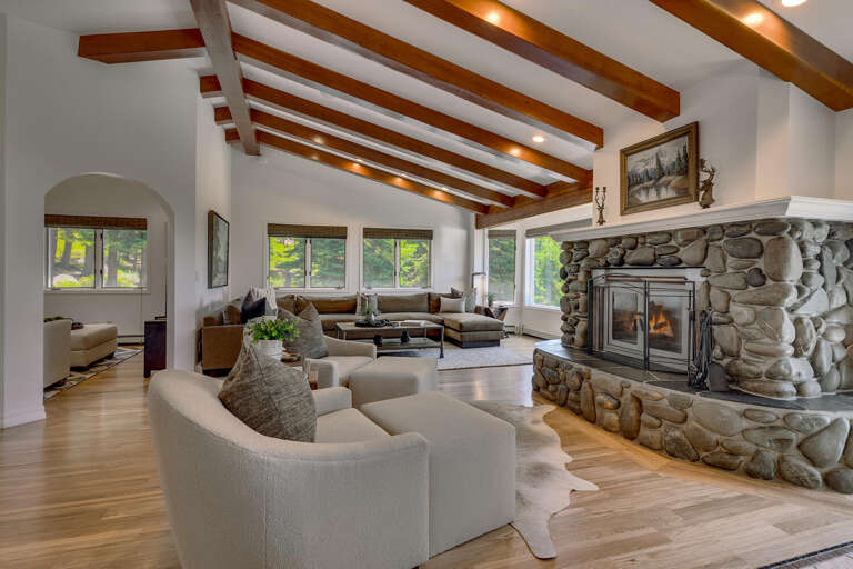 Spacious Vacation Rental Living Room With Stone Fireplace And Wooden Beams