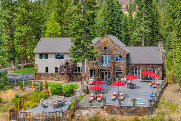 Stone Structure Surrounded By Greenery, Gray Roof And Red Umbrellas