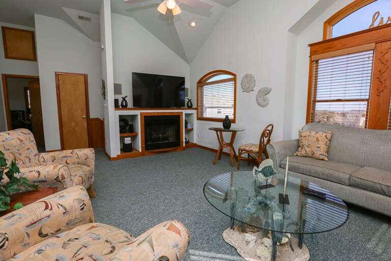 Vacation Rental Living Room With Vaulted Ceilings, Large Windows, And Light Furniture