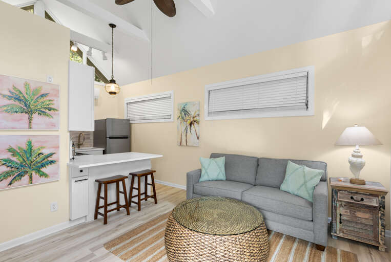 Relax on your cozy sofa and feel the coastal breeze flow through this bright, airy space, where vaulted ceilings and soft natural light create a welcoming retreat after every adventure.