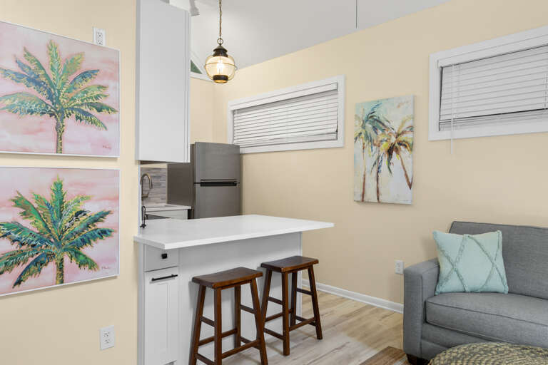 Settle into your bright open-concept space where warm coastal tones, a sunny kitchen island, and beachy artwork invite you to unwind and feel at home from the moment you arrive.