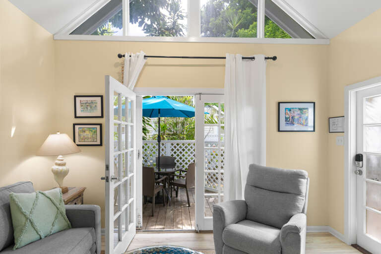 Step through French doors into your private retreat where high ceilings and soft light create an inviting space to unwind. The view of your own patio promises peaceful mornings and quiet evenings outdoors.