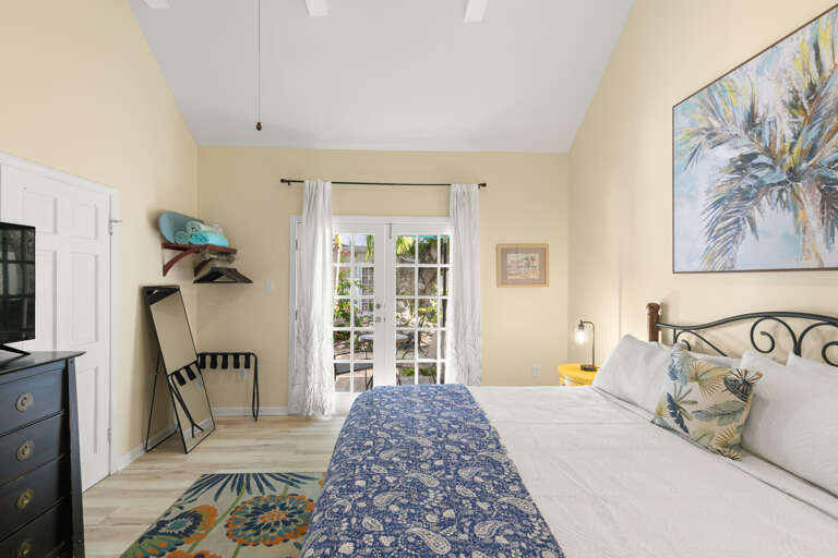 Step into your serene coastal retreat, where soft morning light spills through French doors and touches of blue and tropical accents create the perfect escape for relaxation.