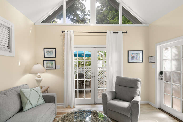 Step into your bright, airy living space where vaulted ceilings and French doors frame stunning ocean views, inviting you to relax in comfort and style.