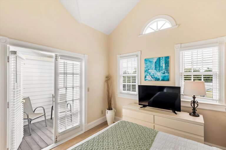 Primary loft style bedroom with balcony access