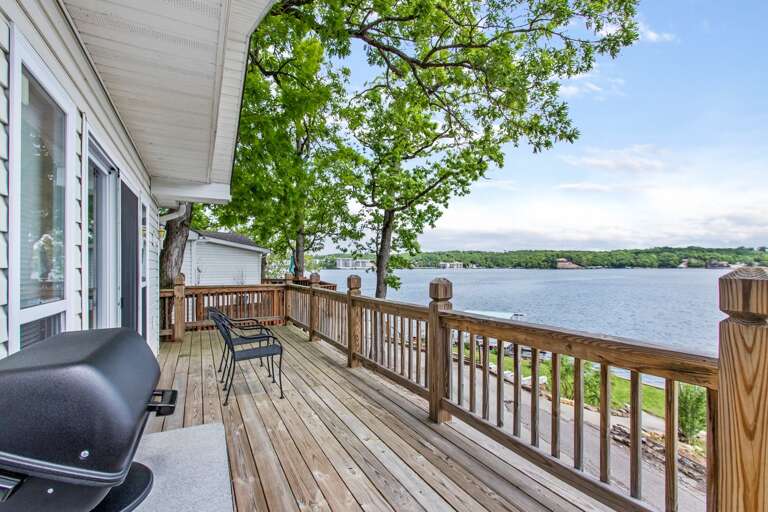 Vacation Rental Balcony Boasting Brilliant Lake View, Luscious Leaves, And Leisurely Lounge Chairs