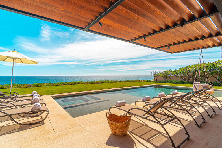 Sea-facing Vacation Rental Pool Patio With Loungers Under A Wooden Pergola