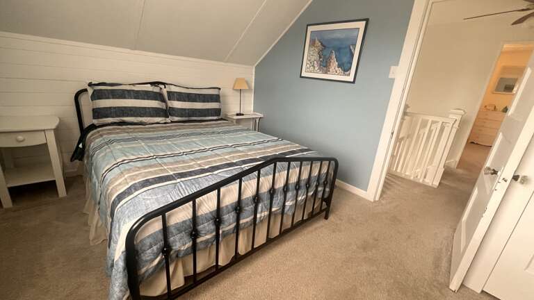 Drift off in this cozy bedroom where soft blue walls and charming striped bedding create your perfect retreat.