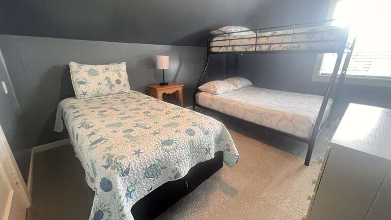 Your cozy bedroom features comfortable single and bunk beds with soft linens, perfect for families or groups sharing peaceful nights together.
