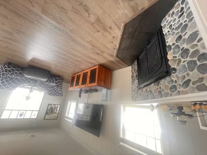 You'll love the rustic charm of this cozy living space, featuring stunning stone fireplace and wood beam ceiling that creates perfect ambiance.