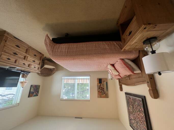 Unwind in your cozy bedroom with rustic wooden furnishings, soft lighting, and artwork that adds character to your peaceful retreat.