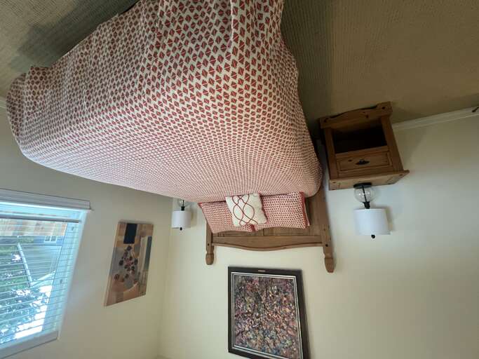 Cozy bedroom with rustic wooden touches and soft red-patterned linens inviting you to unwind after a day of exploring.