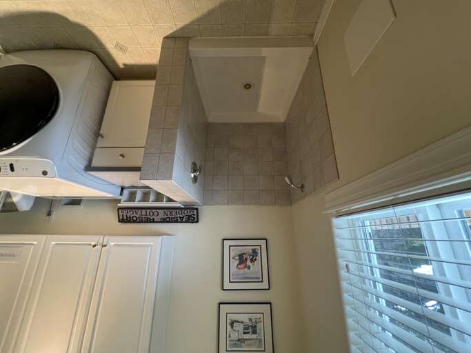 Your private bathroom features a spacious walk-in shower with fresh tiling, plus a washer and dryer for ultimate convenience during your stay.