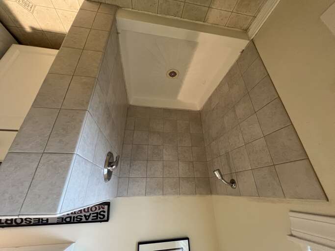 Step into your private walk-in shower with sleek tiled walls and a spacious, clean design perfect for refreshing after a day of adventure.