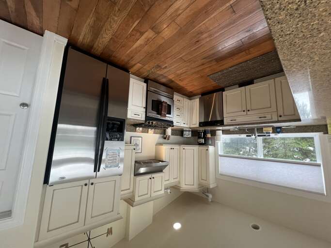Your fully equipped kitchen features warm wood ceilings, modern appliances, and a bright window that brings natural light into your cooking space. Everything you need to prepare delicious meals during your stay.