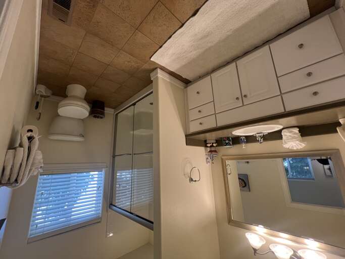 Your private bathroom features elegant tile finishes, a sleek glass shower, and crisp white towels, creating a bright and refreshing space to start your day.