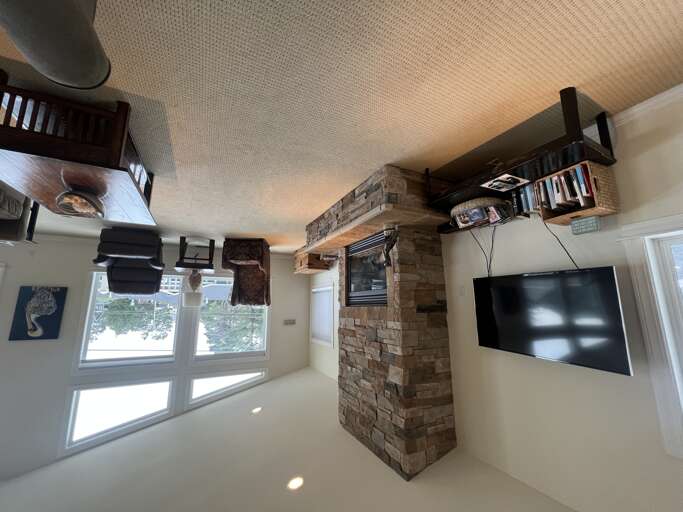 Unwind in your cozy living space with a flat-screen TV, rustic stone fireplace, and charming overhead loftâperfect for relaxing after a day of adventure.