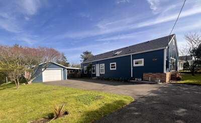 Coastal charm welcomes with deep blue siding and modern touches. Convenient driveway parking make arrival effortless at this inviting property.