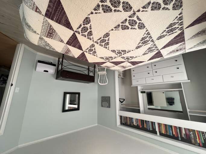 Curl up beneath the charming patchwork quilt surrounded by crisp white built-ins and clever storageâyour cozy reading nook awaits.