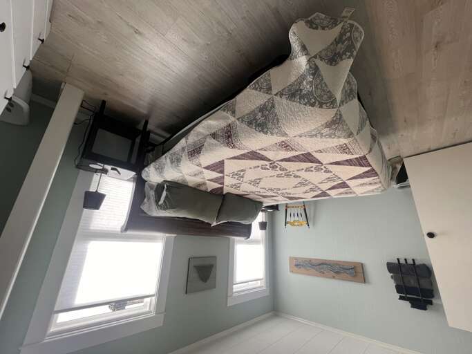 Curl up in your cozy bedroom where natural light pours through bright windows, warming the inviting bed dressed in soft linens and stylish textilesâyour peaceful retreat awaits.