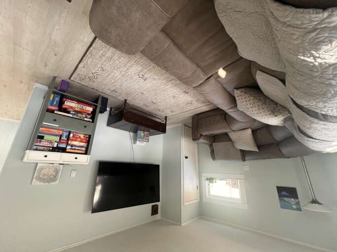 Sink into plush seating in your inviting living spaceâcomplete with a mounted TV, storage for board games and books, and cozy blankets ready for your perfect evening in.