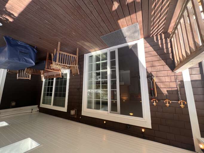Relax on your private covered deck with a porch swing and rocking chairs, where soft lighting sets the perfect mood for evening conversations.