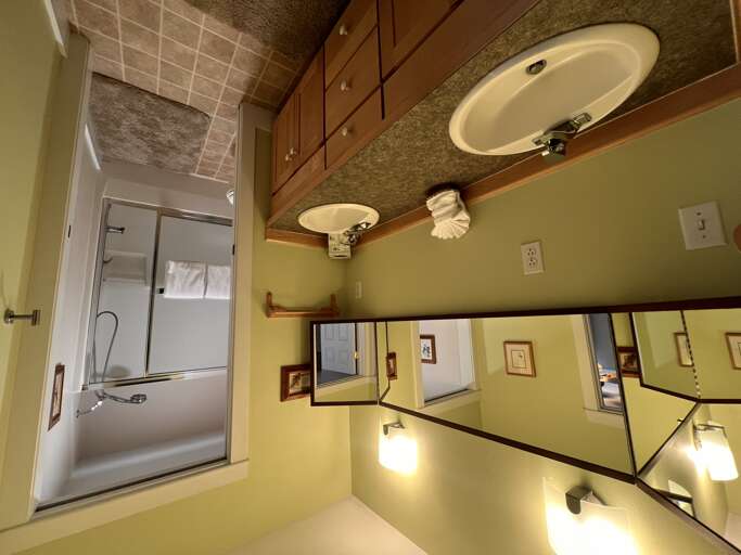 Step into your bright, clean bathroom featuring a granite vanity with double sinks, fresh towels, and a relaxing tub-shower combination ready for you.