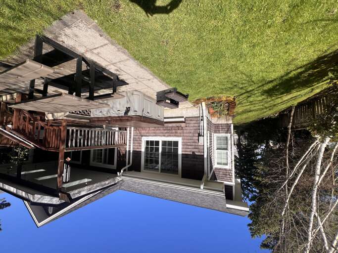Charming coastal property with multiple decks, lush lawn, and peaceful natural surroundings—perfect for your seaside getaway.