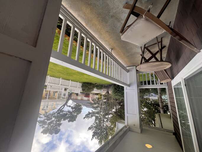 Covered porch with polished ceiling fans and white railings opening to neighborhood views, perfect for your morning coffee or evening wind-down.