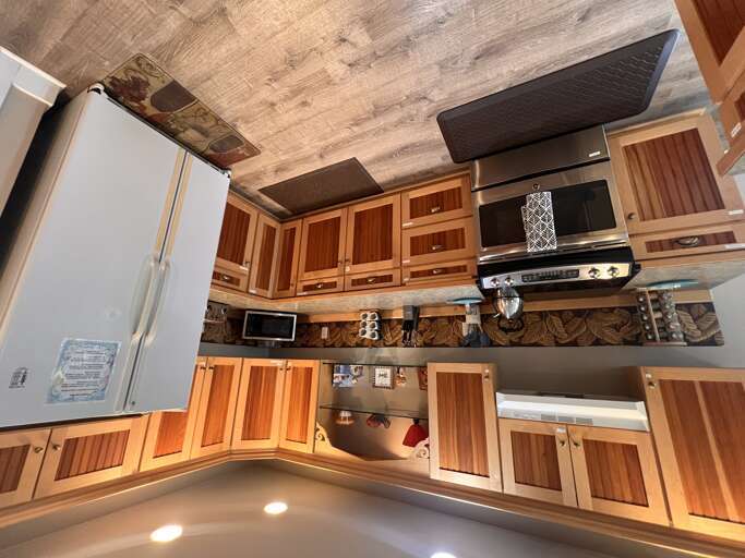 Your fully-equipped kitchen blends rustic elegance with modern convenience, featuring warm wood cabinetry, stainless steel appliances, and custom details perfect for preparing family meals or morning coffee.