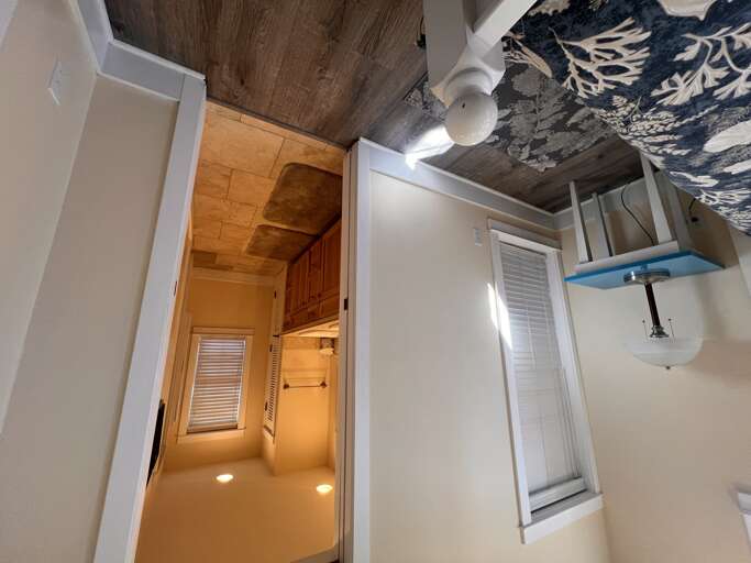Modern bathroom with artistic ceiling detail and warm wood accents creating a unique, stylish retreat for your stay.