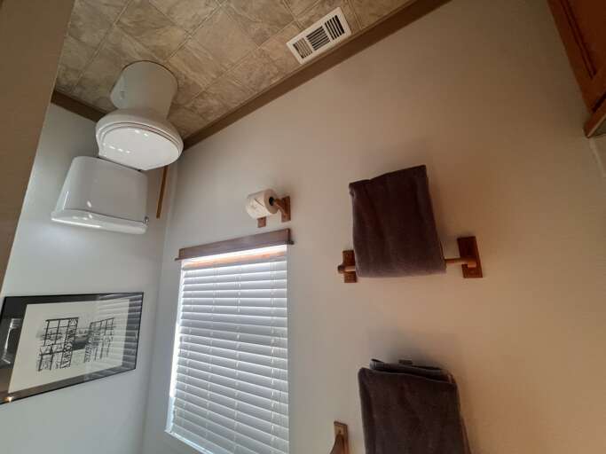 Your bathroom features a modern toilet with plush towels and stylish tile ceiling details creating a comfortable, well-appointed space.