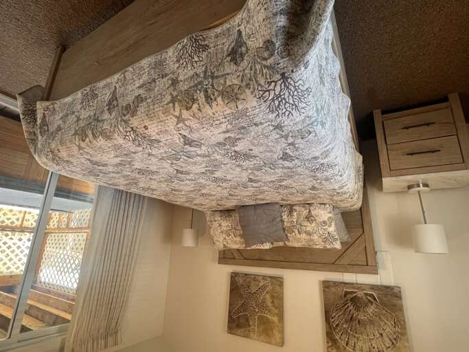 Your cozy bedroom features maritime-themed artwork creating a coastal sanctuary perfect for peaceful nights.