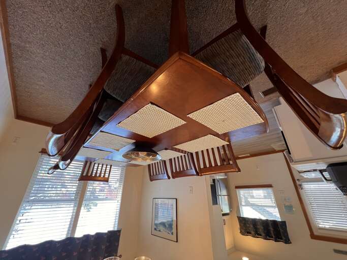 Your cozy dining nook features a stunning inverted table ceiling art piece, creating a whimsical conversation starter for memorable meals.