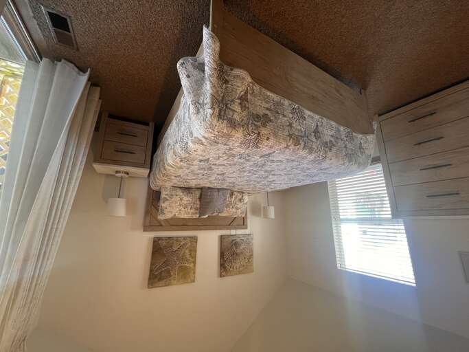 Drift into peaceful sleep beneath coastal artwork and soft linens in your private bedroom retreat.