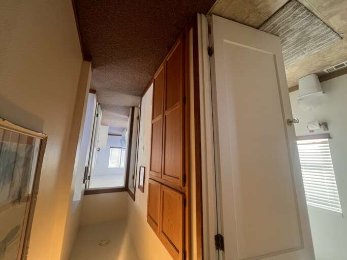 Your private hallway features rich wood cabinetry and thoughtful storage, creating a welcoming path through your home away from home.