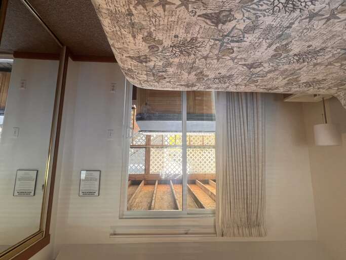 Rest in your cozy bedroom beneath hand-painted ceiling murals, where soft curtains frame peaceful balcony views.
