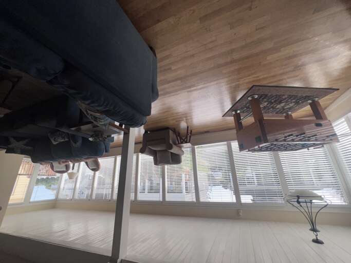 Your bright dining space features a rustic table set against floor-to-ceiling windows, filling your meals with natural light and neighborhood views.